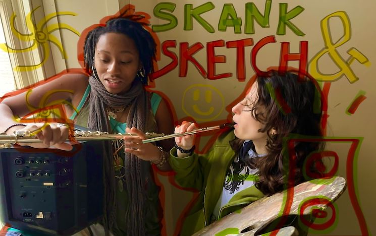 Photo of Hannah and Isla playing with instruments. Hannah holds an amp and flute. Isla holds a flute and a wooden paint palette. The words skank and sketch are drawn over the top of the image in red, green and yellow. 