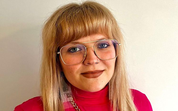 Head shot of Elizabeth Parry wearing glasses and a red top.