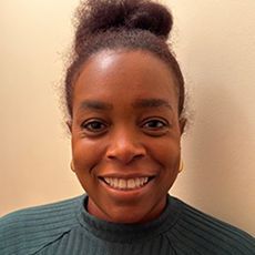 Headshot of a smiling woman against a beige background