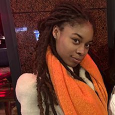 Headshot of a smiling woman wearing an orange scarf