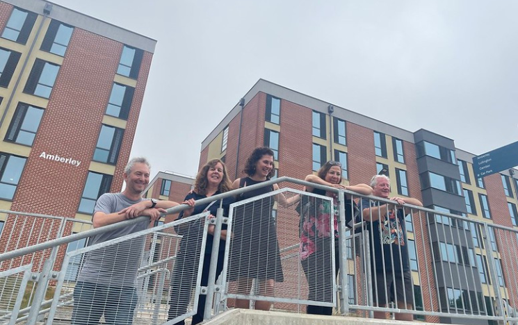A group of Sussex alumni on the steps outside the new East Slope development on campus