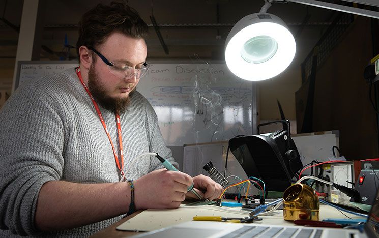 A student working with soldering tools