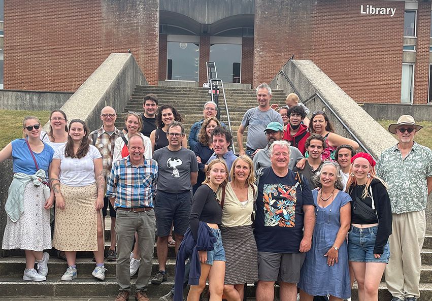 A group of alumni from the mountaineering club gathered on the steps of campus library