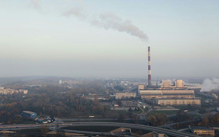 An image of a landscape with a large factory in the distance