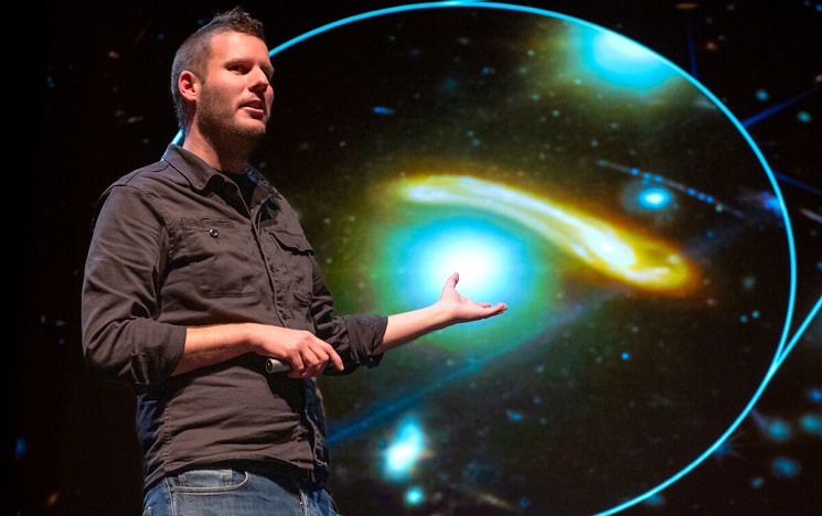 Lecturer on stage presenting a magnified image of moving lights