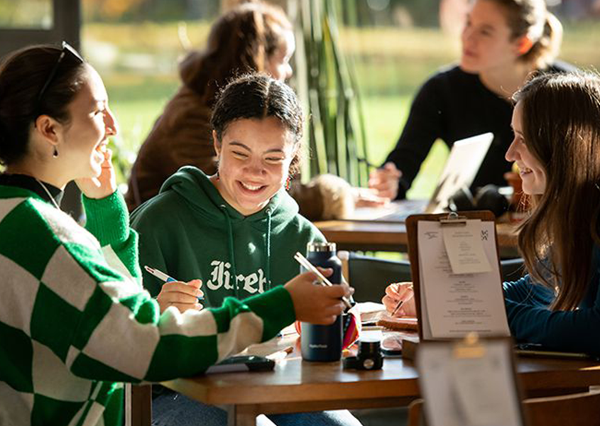Students chatting and smiling in a cafe